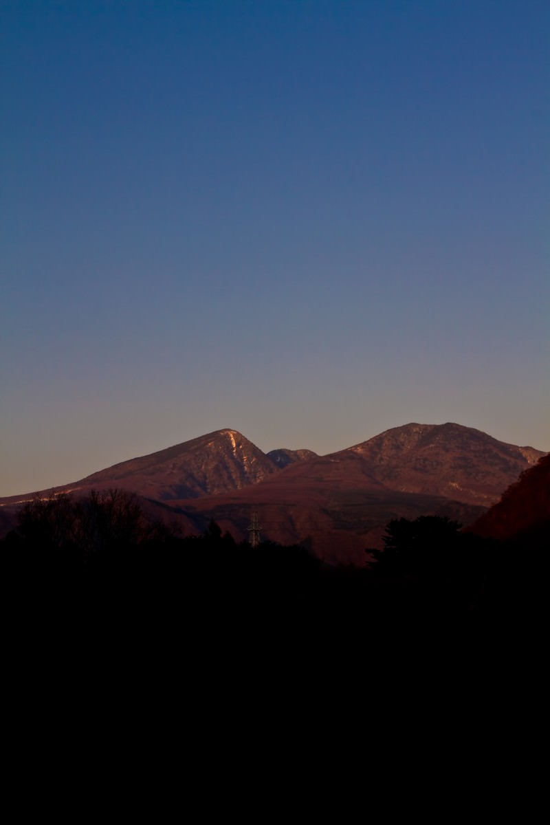 夕暮れの空と雪が残る山並み