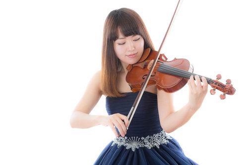 紺のドレス姿でヴァイオリンを演奏する女性