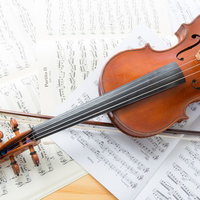 楽譜に置かれたヴァイオリンと弓の写真