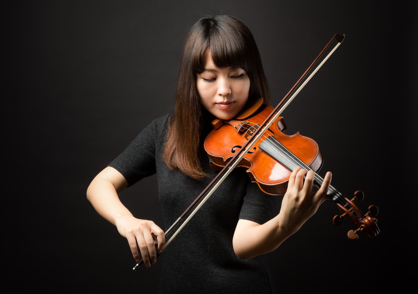 ヴァイオリンを演奏する女性が目を閉じて集中している［モデル：yukiko］