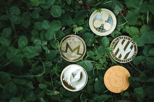 草地に配置された5枚の仮想通貨コイン