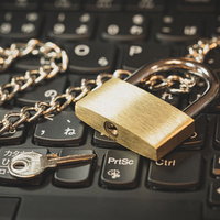 キーボードの上に置かれた南京錠とチェーン、セキュリティの写真