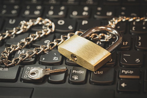 キーボードの上に置かれた南京錠とチェーン、セキュリティ