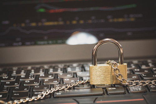 パソコンのキーボードと鎖に繋がれた南京錠