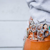 茶色い革製ポーチに入れた犬用シザーケースの写真