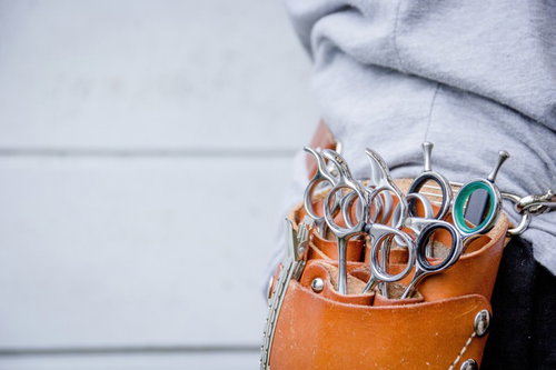 茶色い革製ポーチに入れた犬用シザーケース