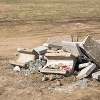 砕けたコンクリートの破片と鉄筋が露出する瓦礫の山の写真