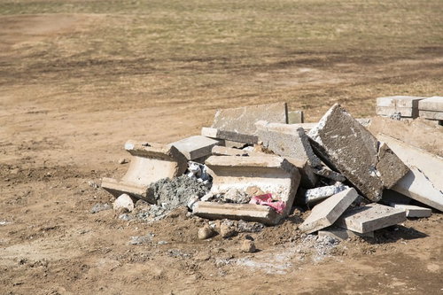砕けたコンクリートの破片と鉄筋が露出する瓦礫の山