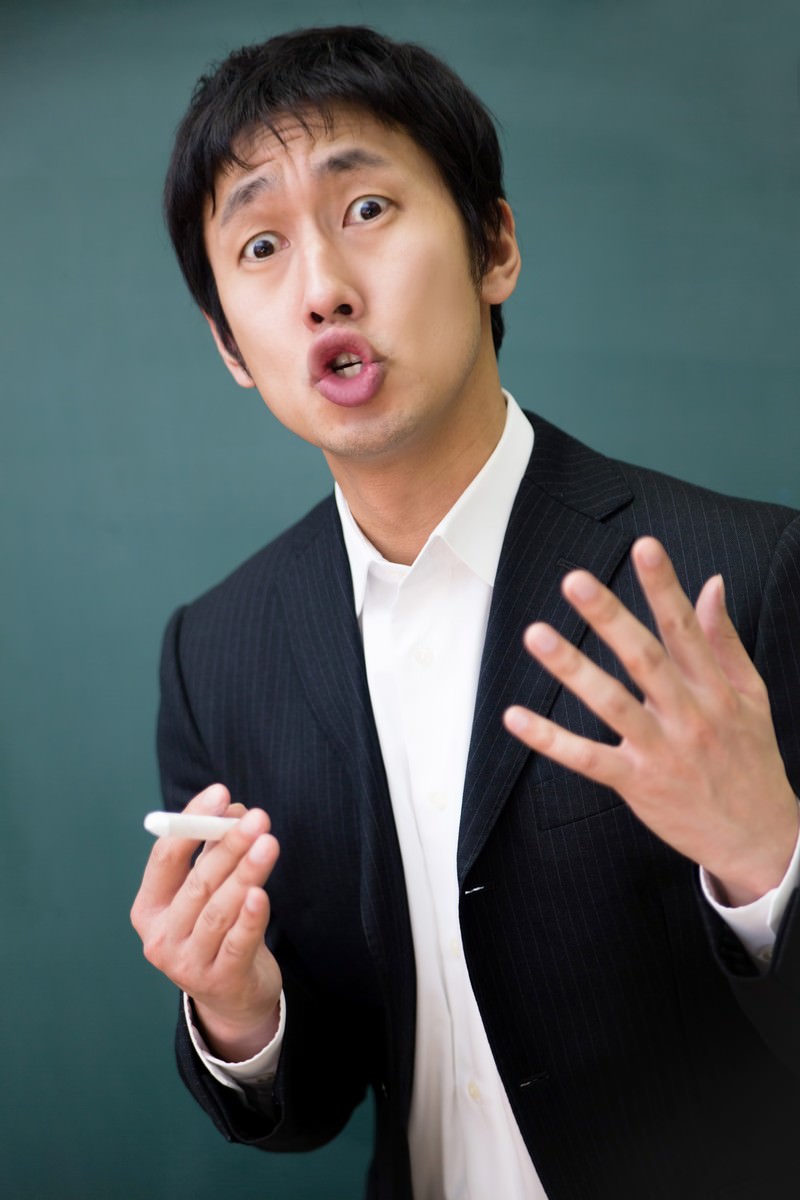チョークを持って熱弁をふるう講師の男性［モデル：大川竜弥］