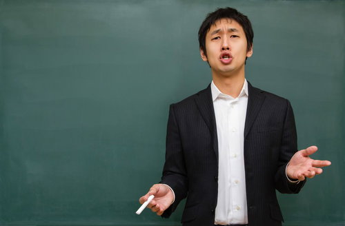 黒板の前で受験の重要性を真剣に語る塾講師の横姿