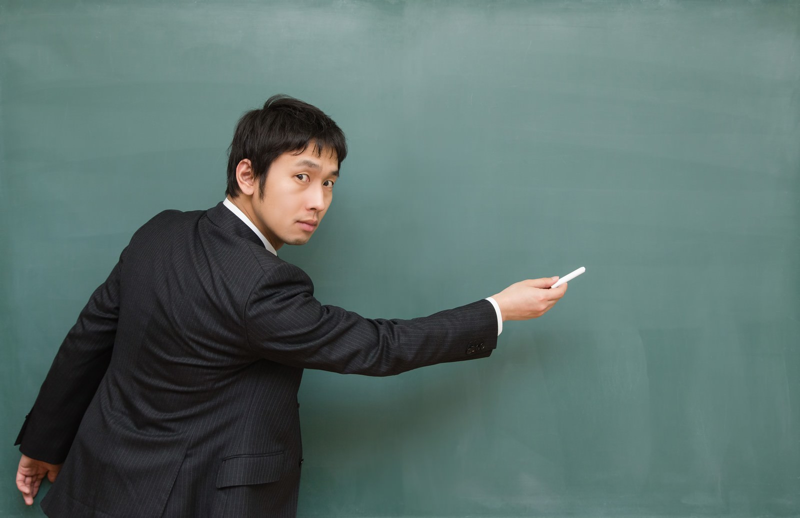 黒板の重要ポイントを指す先生［モデル：大川竜弥］