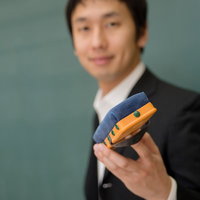 黒板消しを手に持って生徒に渡そうとする先生の手元の写真