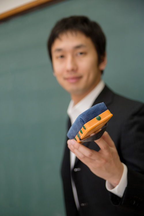 黒板消しを手に持って生徒に渡そうとする先生の手元