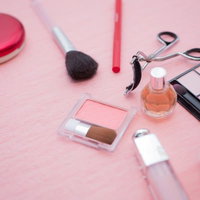 ファンデーションやブラシやリップが並ぶコスメセットの俯瞰の写真