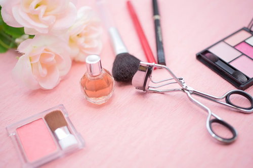 ビューラーやアイシャドウなどメイク道具が並ぶ化粧品の接写