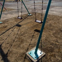 誰もいない昼下がりの公園のベンチとブランコの風景の写真