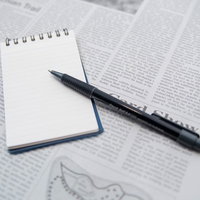翻訳作業中の赤い書き込みがあるメモ用紙とペンの写真