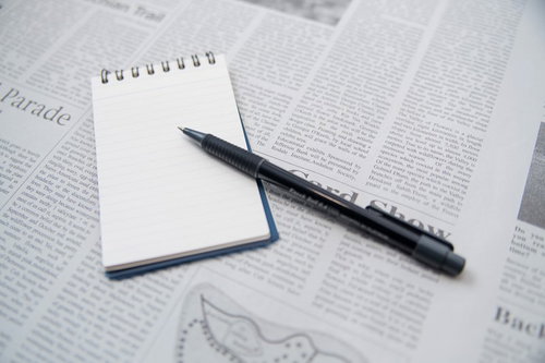 翻訳作業中の赤い書き込みがあるメモ用紙とペン