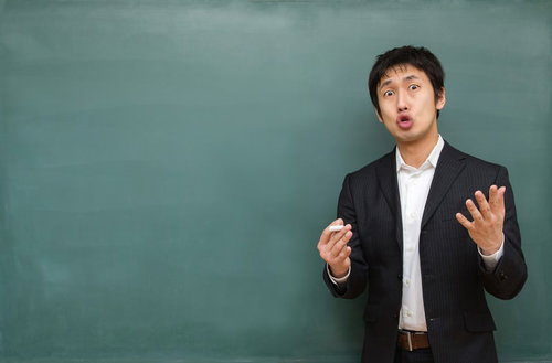 黒板の前で身を乗り出して試験対策を熱く語る塾講師