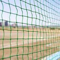 金網のネット越しに見える草野球のグラウンド風景の写真