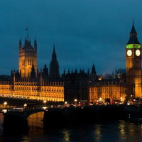 街灯の光とビルの明かりが並ぶ夜のロンドンの通りの写真