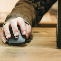 マウスを操作する右手でクリック、デスク上でのPC作業の写真