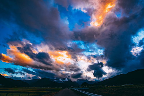 夕暮れ時にオレンジ色に染まる雲と青空の風景