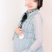 マタニティマークのバッジをつけた妊婦さんの笑顔の写真