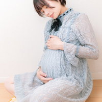 臨月のおなかを両手で優しく触る妊婦のマタニティの写真
