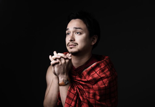 赤いチェック柄シャツで両手を合わせて祈りを捧げる男性