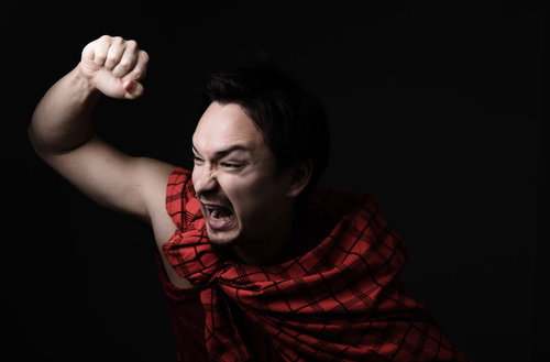 民族衣装の男性が大声で突撃を決めた瞬間の力強い感情表現