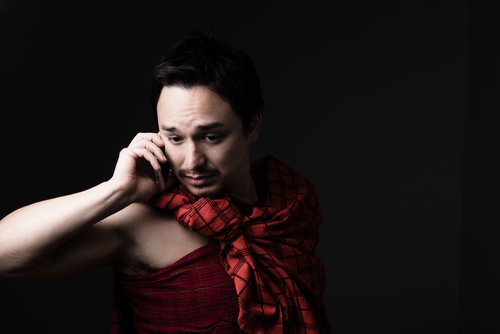 旅行先で離婚を告げられた外国人男性がスマートフォンで通話