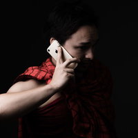 母さん助けて！スマートフォンで通話する男性の写真