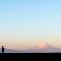 富士山をバックに散歩する男性のシルエットの写真