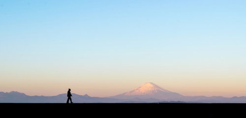 富士山をバックに散歩する男性のシルエット