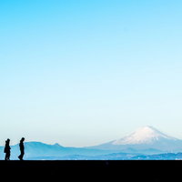 富士山をバックに散歩する二人の男女のシルエットの写真