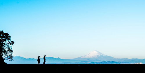 富士山をバックに散歩する二人の男女のシルエット