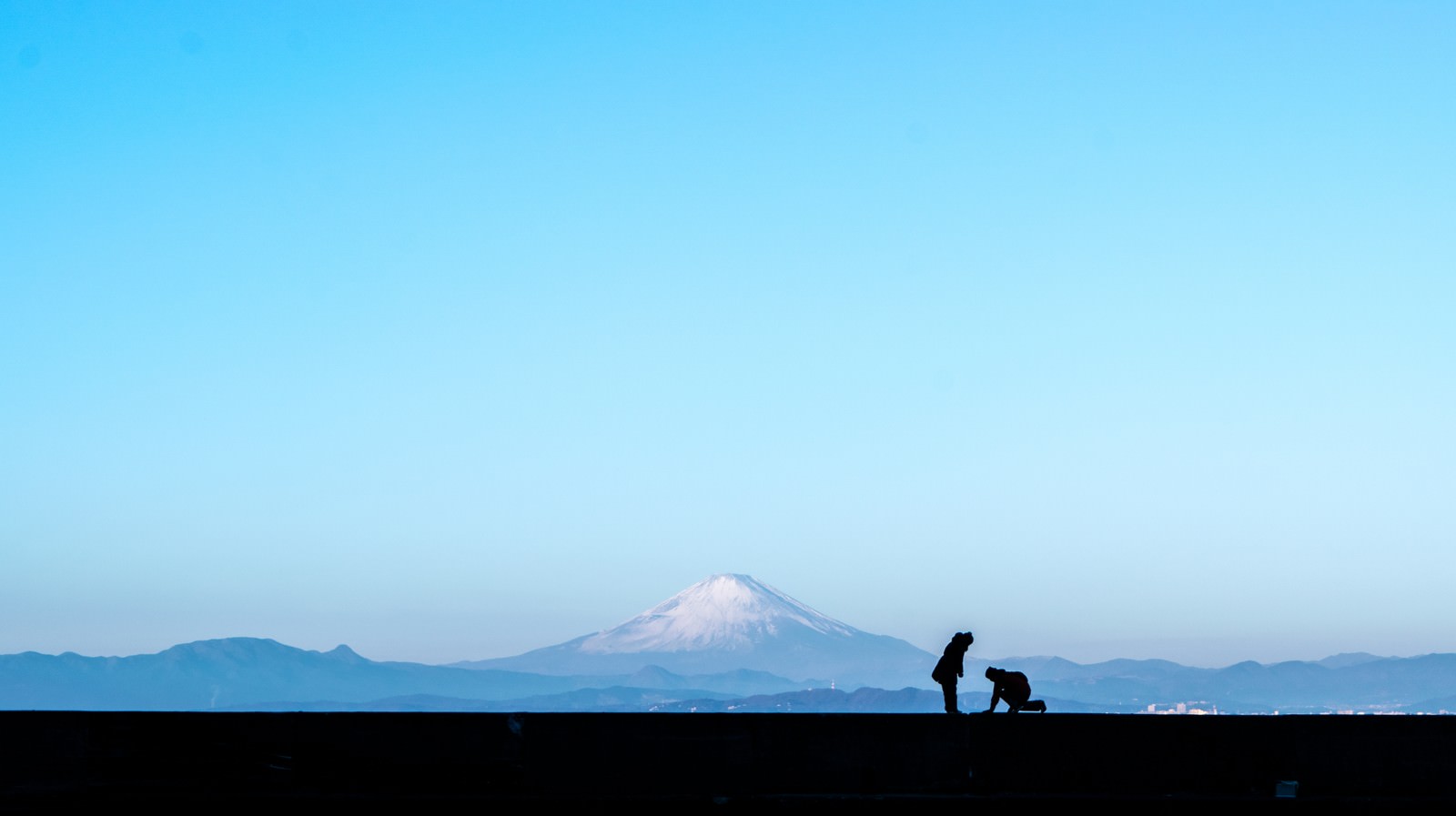 富士山を背景にして寄り添うカップルのシルエット
