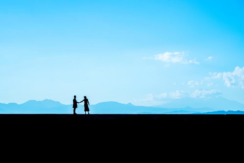 別れを惜しむ二人シルエット、富士山と青空を背景に