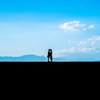 富士山を背景にした景色のいい堤防で顔を近づける恋人たちの写真