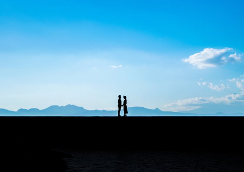 想いを伝える手を繋ぐカップルのシルエット