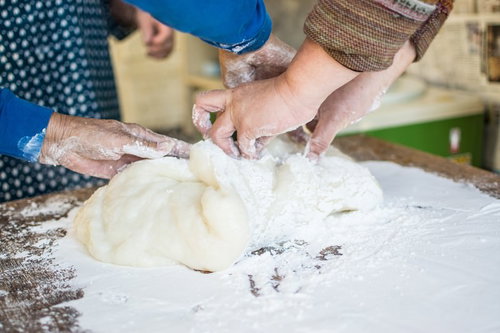 つきたてのお餅に片栗粉（餅とり粉）をまぶす調理風景