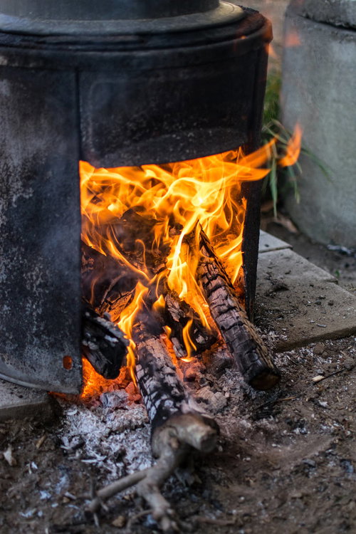 かまどに薪を入れて炎が燃え上がる様子