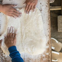 つきたてのお餅を小判型に引き伸ばす作業風景の写真