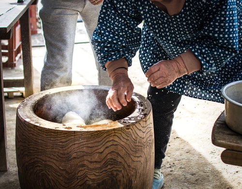 手水で餅をひっくり返す餅つきの様子、つきたての餅を仕上げる