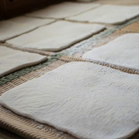 ござの上に片栗粉をまぶして並べられた手作り餅の写真