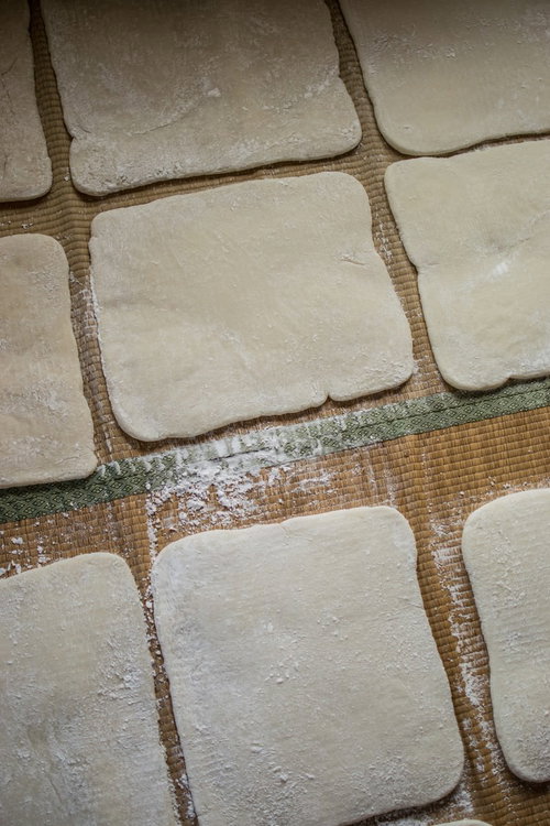 ござの上に並ぶ正方形に整えられた手作りの餅