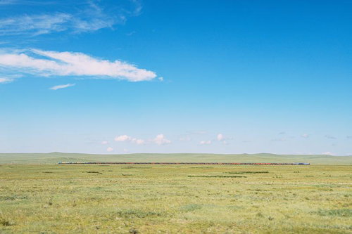 モンゴルの広大な草原を走る貨物列車と雄大な地平線