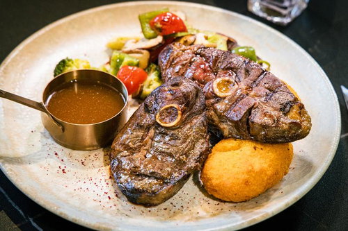 骨付きマトンステーキと焼き野菜の盛り付けプレート