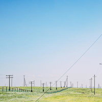 緑の草原に立ち並ぶ電柱と送電線、モンゴルの広大な平原の写真